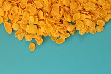 Kahvaltı gevreklerinin arka planında büyük miktarda mavi arka planda yakın plan, üst manzara.