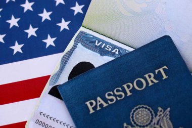 Pasaportlu ABD ziyaretçi vizesi ve Amerika Birleşik Devletleri bayrağı altında ABD pasaportu. Seyahat ve göç kavramı