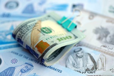 Birleşik Arap Emirlikleri kara para birimi faturaları ve biz dolar banknotları yakın yakın. Ekonomi ve döviz kuru kavramı