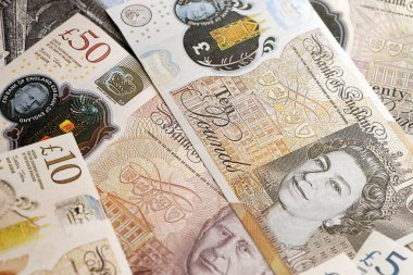 KYIV, UKRAINE - SEPTEMBER 17, 2025 Big pile of British pound money bills on table close up