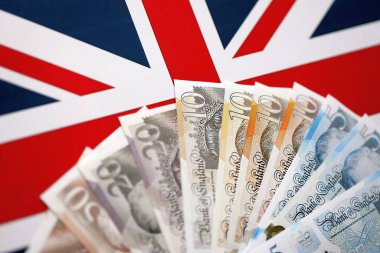 KYIV, UKRAINE - SEPTEMBER 17, 2025 Big amount of British pound money bills on Union Jack flag close up