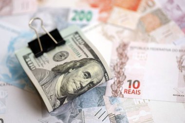 Bir sürü Amerikan doları büyük miktarda Brezilya banknotunun üzerinde yatar. Amerika 'nın parası Brezilya' nın para akışına bağlı. Brezilya 'da ekonomi ve döviz kuru kavramı