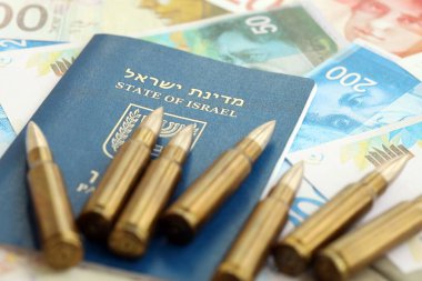 Israel New Shekels banknotları ve pasaportlu mermiler. İsrail 'in şu anki para ve mühimmatı büyük miktarda masada yatıyor. İsrail 'de askerlik kavramı