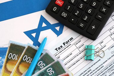 İsrail 'in yeni şekeri, hesap makinesi ve bayraktaki vergi formuyla para basıyor. Şu anki İsrail parası ve vergileri yakın plan. İsrail 'de vergi ödeme ve muhasebe kavramı