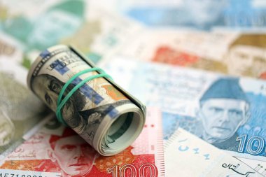 Amerikan dolarlarının rulosu Pakistan 'daki büyük miktardaki banknotların üzerinde yatıyor. Amerikan para demeti Pakistan 'ın para banknotlarında yatıyor. Pakistan 'da ekonomi ve döviz kuru kavramı