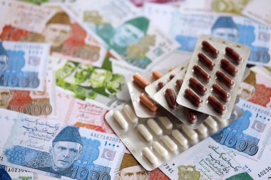 Pakistan banknotları ve ilaç hapları. Pakistan 'ın mevcut para ve uyuşturucu faturaları büyük miktarda masada yatıyor. Pakistan 'da ilaç ve eczane kavramı