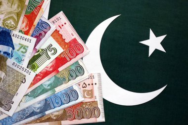 Pakistan 'ın bayrak geçmişi üzerine Pakistan banknotları. Pakistan 'ın mevcut para faturaları büyük miktarlarda pankartta yatıyor. Pakistan 'da ekonomi ve ticaret kavramı