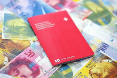 İsviçre frangı banknotları ve pasaportu. Mevcut banknotlar ve biyometrik geçiş kartları büyük miktarda masada yatıyor. İsviçre 'de seyahat ve tatil kavramı