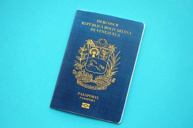 Venezuelan passport book on light blue paper background close up. Travel document on blue surface