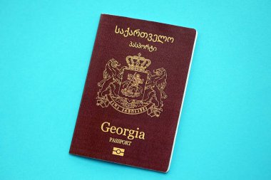 Georgian passport book on light blue paper background close up. Travel document on blue surface