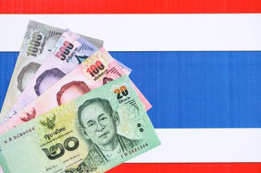 Tayland baht para birimi faturaları bayrağın üzerinde duruyor. İş ve yatırım kavramı