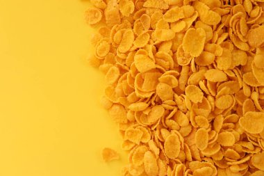 Kahvaltı gevreklerinin arka planında büyük miktarda sarı arka planda yakın plan, üst manzara