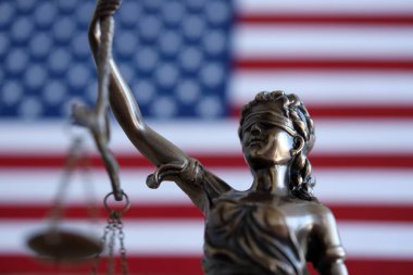 Hukuk ve adalet Amerika Birleşik Devletleri'ndeki bürolarından denetlenmekte, heykel Bayan Adalet ABD bayrağı arka planda, seçici odak ile