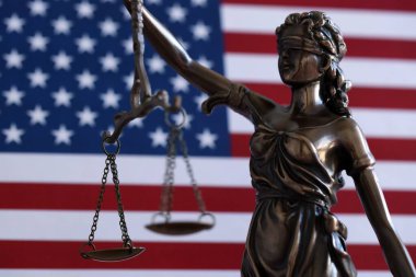Hukuk ve adalet Amerika Birleşik Devletleri'ndeki bürolarından denetlenmekte, heykel Bayan Adalet ABD bayrağı arka planda, seçici odak ile