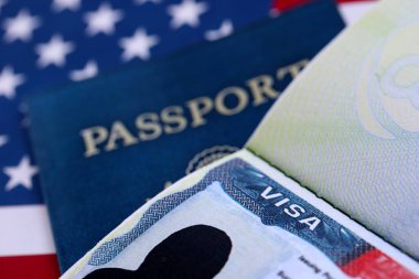 Pasaportlu ABD ziyaretçi vizesi ve Amerika Birleşik Devletleri bayrağı altında ABD pasaportu. Seyahat ve göç kavramı