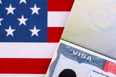 Birleşik Devletler bayrağı ve Birleşik Devletler vizesi. Göçmenlik ve Amerika Birleşik Devletleri 'ne seyahat kavramı. Amerikan bayrağının arka planındaki pasaportta vize var.