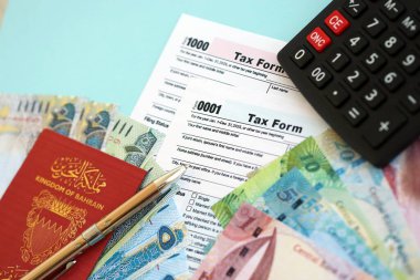 Bahreyn dinar para faturaları ve mavi üzerine yakın vergi formlu hesap makinesi. Vergi ve muhasebe kavramı