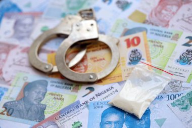 Nijerya naira para birimi faturaları ve kelepçeli kokain paketi. Uyuşturucu suçları kavramı