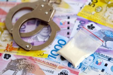 Filipinler Peso para birimi faturaları ve kelepçeli kokain paketleri. Uyuşturucu suçları kavramı