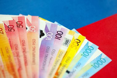 Filipinler Peso para birimi banknotları bayrağın üzerinde duruyor. İş ve yatırım kavramı