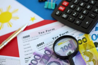 Filipinler pezosu para faturaları ve vergi formlu hesap makinesi. Vergi ve muhasebe kavramı