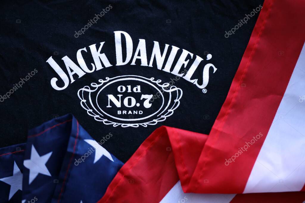 KYIV, UKRAINE - AUGUST 31, 2025 Jack Daniels Tennessee sour mash Whiskey logotype on fabric with US flag close up