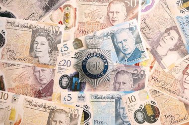 KYIV, UKRAINE - SEPTEMBER 17, 2025 UK Metropolitan Police badge on British pound money bills close up