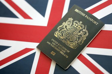 KYIV, UKRAINE - 17 Eylül 2025 İngiliz bayrağında yeni siyah İngiliz pasaportu