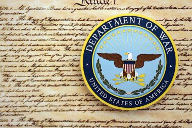 KYIV, UKRAINE - SEPTEMBER 17, 2025 US Department of War badge on first page of US Constitution replica close up