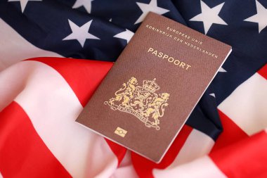 Hollanda pasaportu Amerika Birleşik Devletleri bayrağında sallanıyor. ABD Vize ve Göçmenlik Konsepti