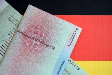 Alman geçici oturma izni numunesi Almanya bayrağına yakın duruyor. Fiktionsscheinigung
