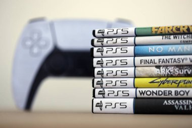 KYIV, UKRAINE - 17 Eylül 2025 PS5 video oyun disk kutuları ve modern dualsense kenar oyun sahası yakınlaşması