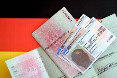 KYIV, UKRAINE - 31 Ağustos 2025 Alman daimi oturma kartı ve geçici belge Almanya bayrağında yer almaktadır. Aufenthaltstitel ve Fiktionsbescheinung