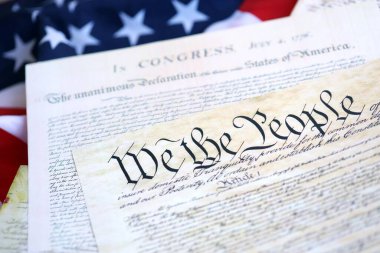 Constitution of the USA with US flag. Aged historical documents Washington DC on American Declaration of independence
