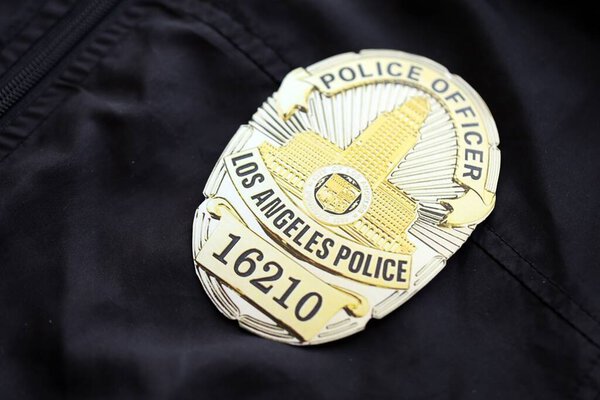 KYIV, UKRAINE - SEPTEMBER 17, 2025 US LAPD Police officer badge on black uniform fabric surface close up