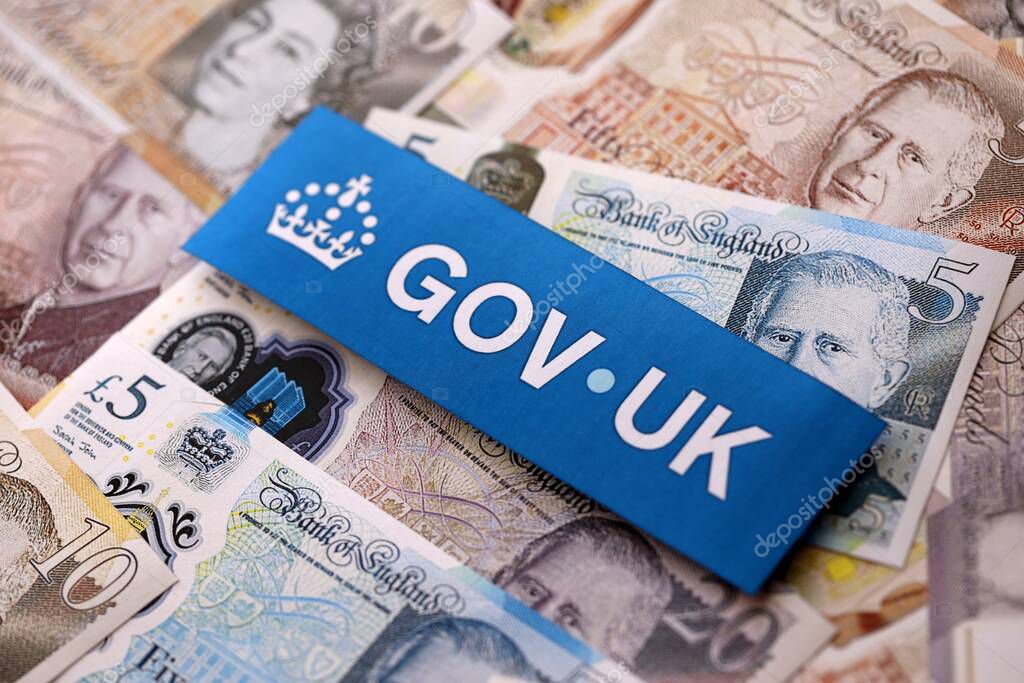KYIV, UKRAINE - SEPTEMBER 17, 2025 Government GOV UK logotype sticker lies on British pounds money bills close up