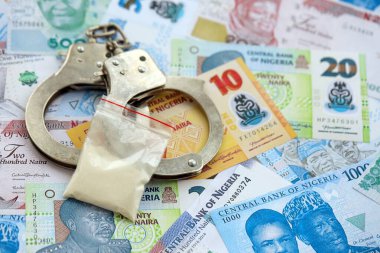 Nijerya naira para birimi faturaları ve kelepçeli kokain paketi. Uyuşturucu suçları kavramı