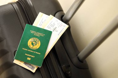 Nijerya pasaportu ve seyahat çantasındaki uçak biletleri yakın plan. Seyahat ve tatil kavramı