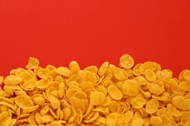 Kahvaltı gevreklerinin arka planında büyük miktarda kırmızı arka planda yakın plan, üst manzara.