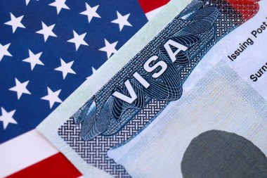 Birleşik Devletler bayrağı ve Birleşik Devletler vizesi. Göçmenlik ve Amerika Birleşik Devletleri 'ne seyahat kavramı. Amerikan bayrağının arka planındaki pasaportta vize var.