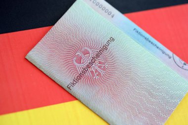 Alman geçici oturma izni numunesi Almanya bayrağına yakın duruyor. Fiktionsscheinigung