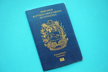Venezuelan passport book on light blue paper background close up. Travel document on blue surface