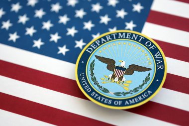 KYIV, UKRAINE - 17 Eylül 2025 ABD Savaş Bakanlığı rozeti Amerika Birleşik Devletleri bayrağına yakın