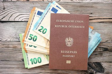 Avusturya pasaportu, tahtadan arka planda Avro para banknotlarıyla birlikte yakın planda bulunuyor. Avrupa konseptinde nakit ve ödemeler