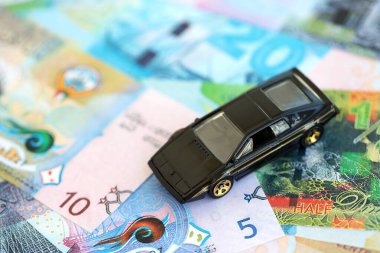 Kuveyt dinarı para ve oyuncak araba faturaları. Araba sahibi olma kavramı.