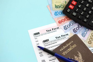 Tayland baht para faturaları ve mavi üzerine yakın vergi formlu hesap makinesi. Vergi ve muhasebe kavramı