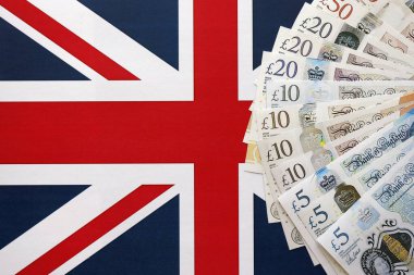KYIV, UKRAINE - SEPTEMBER 17, 2025 Big amount of British pound money bills on Union Jack flag close up