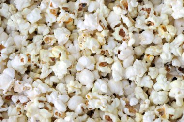 Büyük miktarda tuzlanmış patlamış mısır, sıcak sarı tonlarda. Yaklaş.