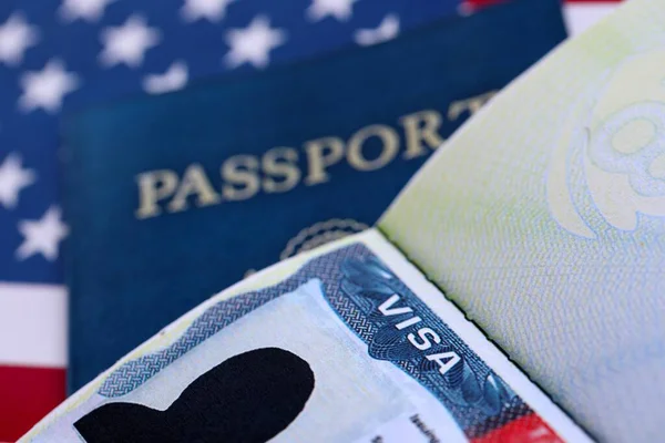 Pasaportlu ABD ziyaretçi vizesi ve Amerika Birleşik Devletleri bayrağı altında ABD pasaportu. Seyahat ve göç kavramı