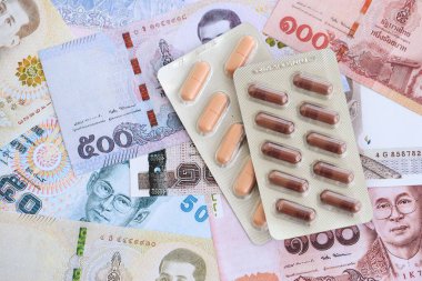 Tayland baht para birimi faturaları ve ilaç hapları. İlaç ve eczane kavramı